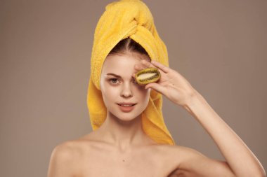 Çıplak omuzlu, elinde kivi olan güzel bir kadın. Yüksek kalite fotoğraf