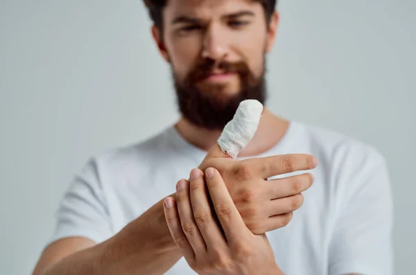 Paciente masculino vendado lesión en la mano a los dedos aislado fondo —  Fotos de Stock