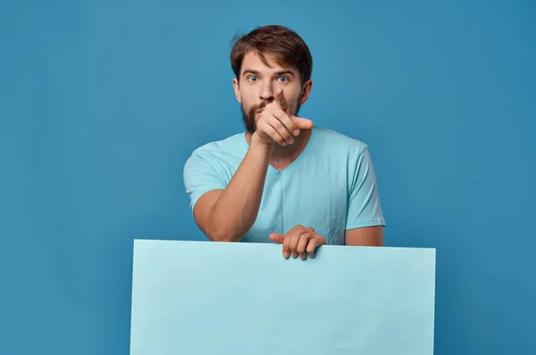 Vrolijke man blauwe banner in de hand blanco blad presentatie geïsoleerde achtergrond — Stockfoto