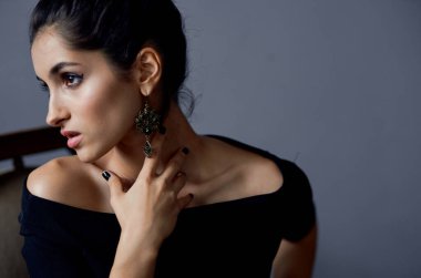 Siyah elbiseli kadın sandalyede oturmuş dekorasyon yapıyor.