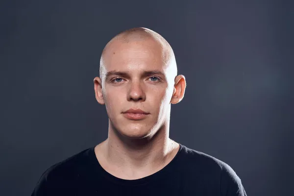 bald man in black cat studio portrait dark background