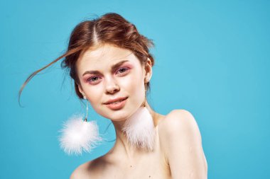 Çıplak omuzlu, parlak makyajlı, mavi arka planda seksi bir kadın. Yüksek kalite fotoğraf