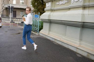 Binanın yakınındaki sokakta oturan kısa saçlı kadın. Yaşam tarzı.