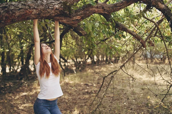 Vacker kvinna sitter nära ett träd natur livsstil sommar — Stockfoto