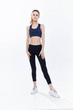 Neşeli, sportif, bacaklı bir kadın. Antrenman yaparak atlıyor.
