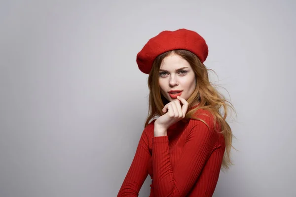 Bonita mujer con una gorra roja en su cabeza glamour estudio posando — Foto de Stock