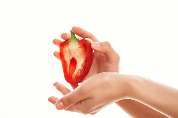 Pokrojone w pół czerwoną paprykę w dłoniach na jasnych warzywach tła — Zdjęcie stockowe