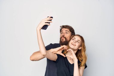 Siyah tişörtlü bir aile. Telefon eğlenceli. Arkadaşlık izole edilmiş bir geçmiş.