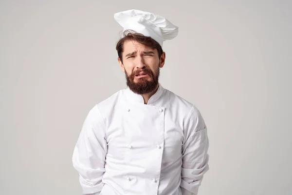 male cook  at work in  uniform on  light background. High quality photo