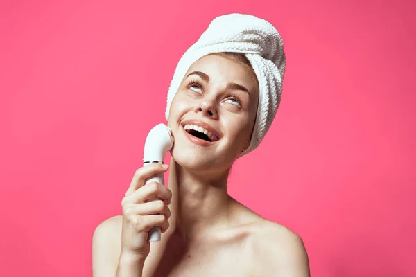 ピンクを背景に頭にタオルをつけた女性 高品質の写真 — ストック写真