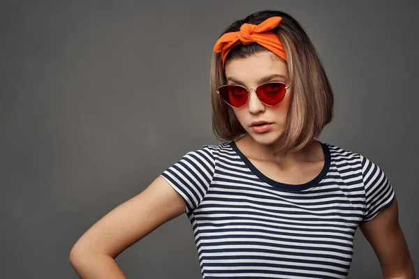 Donna che indossa occhiali da sole in una t-shirt a righe con una benda sulla testa posa moda — Foto Stock