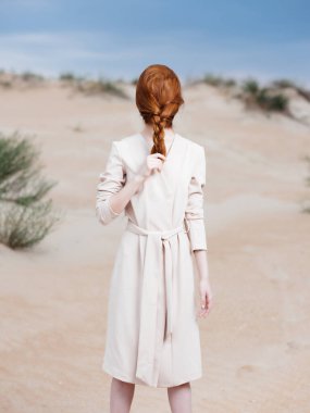 Kadın ceketli, sakallı kumsal adasında seyahat ediyor.