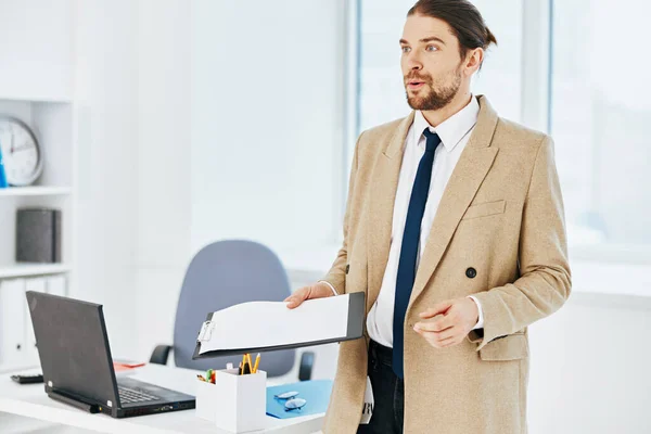 Mann in beiger Jacke im Büro mit Dokumenten — Stockfoto