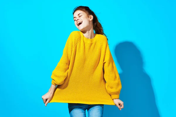 Mujer en suéter amarillo sosteniendo pelo azul fondo moda — Foto de Stock