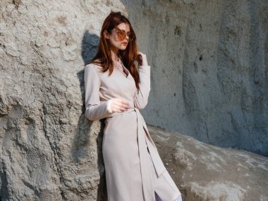 Kum modelinde kayaların yanında poz veren güzel bir kadın Seyahat et