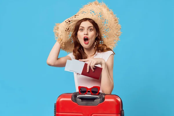 Woman with red suitcase sitting on the floor blue background travel vacation — Stock Photo, Image