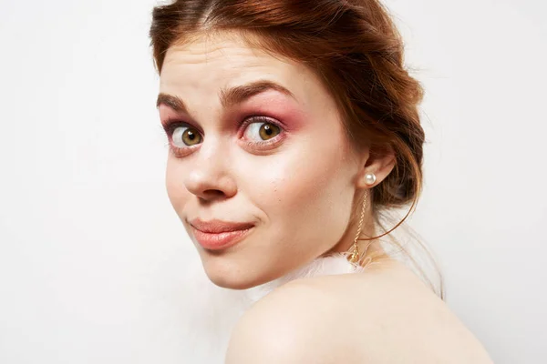 Hübsche Frau flauschige Ohrringe nackte Schultern Nahaufnahme helles Make-up — Stockfoto