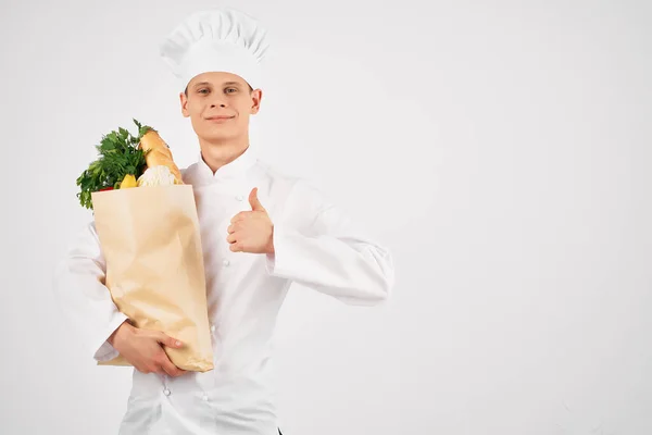 Un uomo in uniforme chef con un pacchetto di prodotti ristorante servizio cucina — Foto Stock