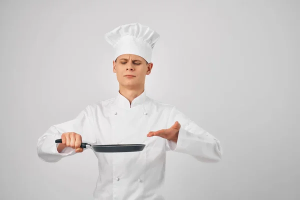 Uomo in cuochi vestiti padella nelle mani lavoro di cucina professionale — Foto Stock