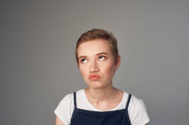 Neşeli, kısa saçlı, makyajlı, aydınlık bir arka plan.