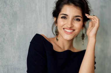 Siyah elbiseli güzel bir kadın ve yüz makyajı zarif bir tarz.