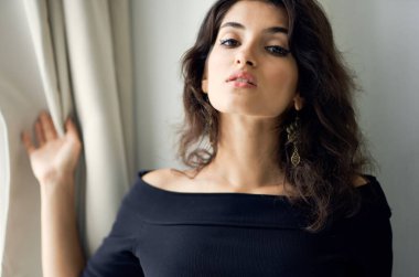 Güzel esmer, siyah elbiseli, lüks bir model.