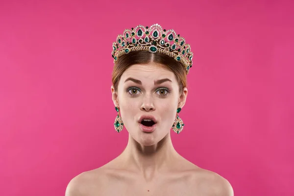 Bela mulher com uma coroa em sua cabeça maquiagem decoração rosa fundo — Fotografia de Stock