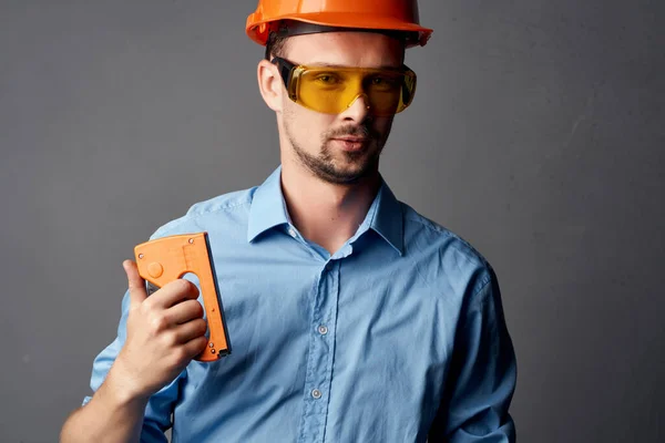 Wesoły człowiek w pomarańczowej konstrukcji twardego kapelusza narzędzi bezpieczeństwa — Zdjęcie stockowe