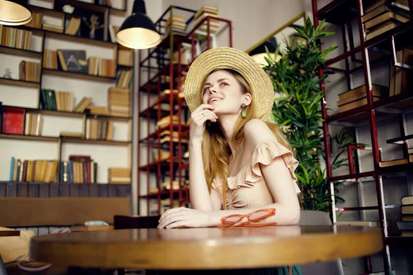 Vacker kvinna sitter vid bordet biblioteket vila läsning — Stockfoto