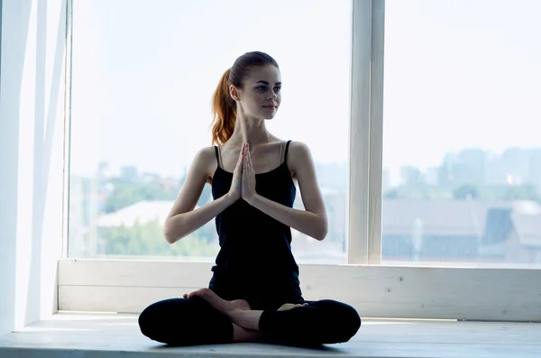 Mujer medita cerca de ventana ejercicio de equilibrio tranquilo — Foto de Stock