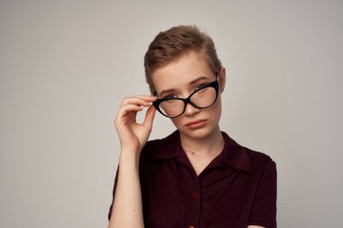 Kısa saç gözlüğü stüdyosunda poz veren şık bir kadın.