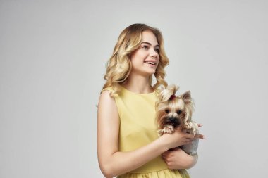 Sarı elbiseli bir kadın. Eğlenceli. Küçük bir köpek izole edilmiş.