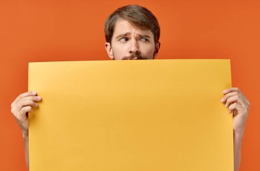 Komik adam reklam yapıyor. Fotokopi alanı turuncu arka planı.