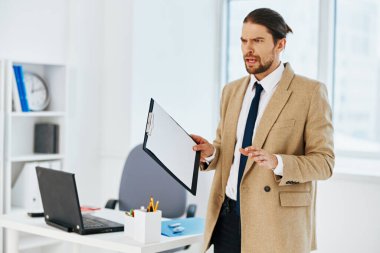 Bej ceketli adam. Resmi belgeler. Ofis teknolojileri.