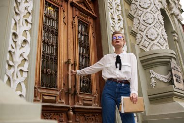 Elinde kitap olan güzel bir kadın dışarıda iletişim kuruyor.