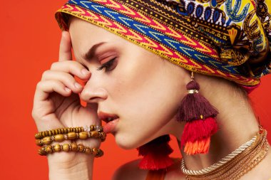 Neşeli kadın, çok renkli şal, etnik köken, Afrikalı tarzı dekorasyon, kırmızı arka plan.