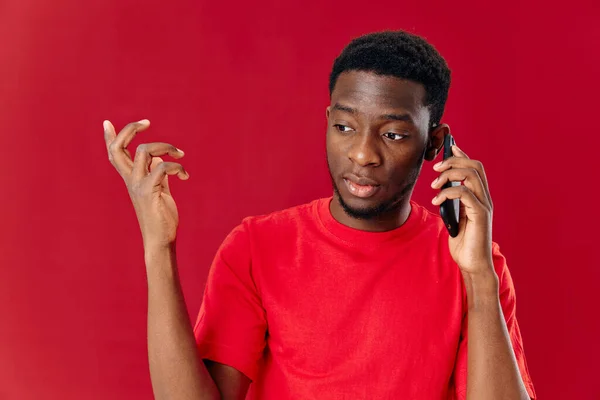 Homem de aparência africana falando ao telefone em um fundo isolado — Fotografia de Stock