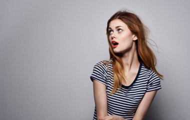 Güzel bir kadın elinde saç makyajı ile komik bir moda ifadesi takınıyor.