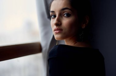 Pencere kenarındaki güzel kadın çekici görünüm küpe yaşam tarzı stüdyosu