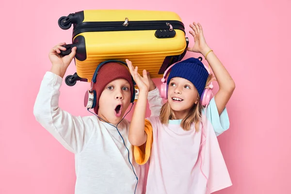 헤드폰 스튜디오 포즈를 취한 웃긴 소년 과 소녀의 노란 가방 — 스톡 사진