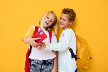 Akıllı telefona bakıp izole edilmiş oyunlar oynayan sevimli çocuklar.