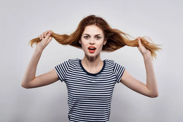 Bella donna tenuta capelli trucco posa divertente moda luce sfondo — Foto Stock