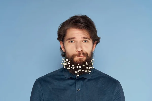 Homem bonito em chapéu posando flores em barba moda azul fundo — Fotografia de Stock