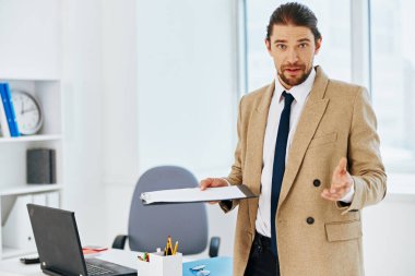 Bej ceketli adam. Resmi belgeler. Ofis teknolojileri.