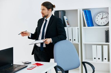 Ofiste takım elbiseli bir adam var. Hayat tarzı belgeli.