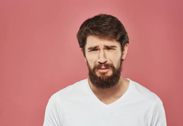 Hombre barbudo emocional en blanco camiseta rosa fondo estudio —  Fotos de Stock