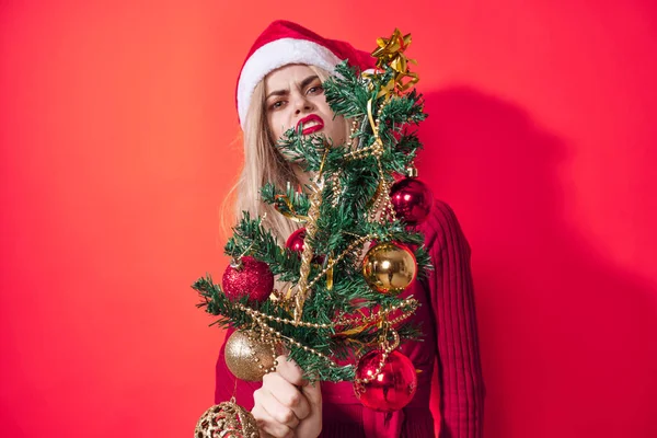 Jolie femme tenant arbre de Noël décoration vacances amusant fond rouge — Photo