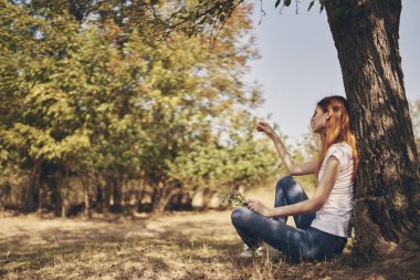 Kadın ağaç doğasının yanında oturuyor Yaşam tarzı yaz