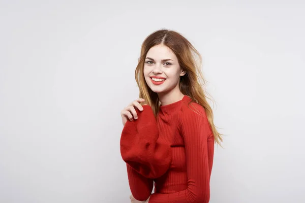 Mulher alegre em um estúdio de emoção de cosméticos de suéter vermelho posando — Fotografia de Stock