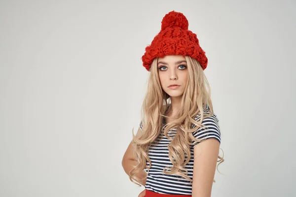 티셔츠를 입은 빨간 모자를 쓴 아름다운 여인 이 글 라머를 보고 있다 — 스톡 사진